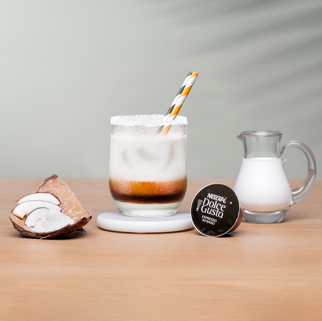 iced latte next to a coffee capsule